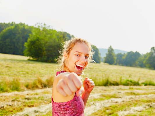 Woman thrusting fist at the camera with a countryside background