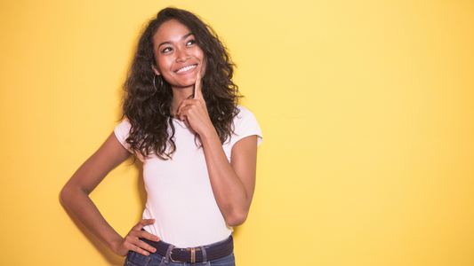 Woman in a thinking pose with a yellow background