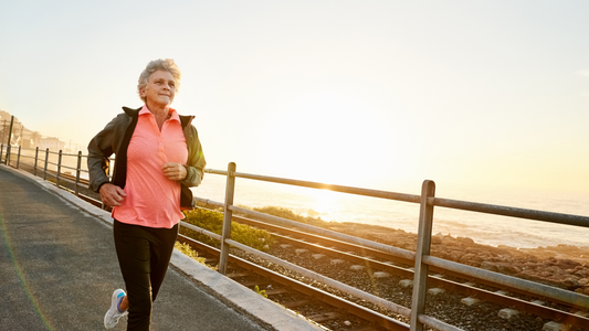 Woman running beside a railroad next to the ocean