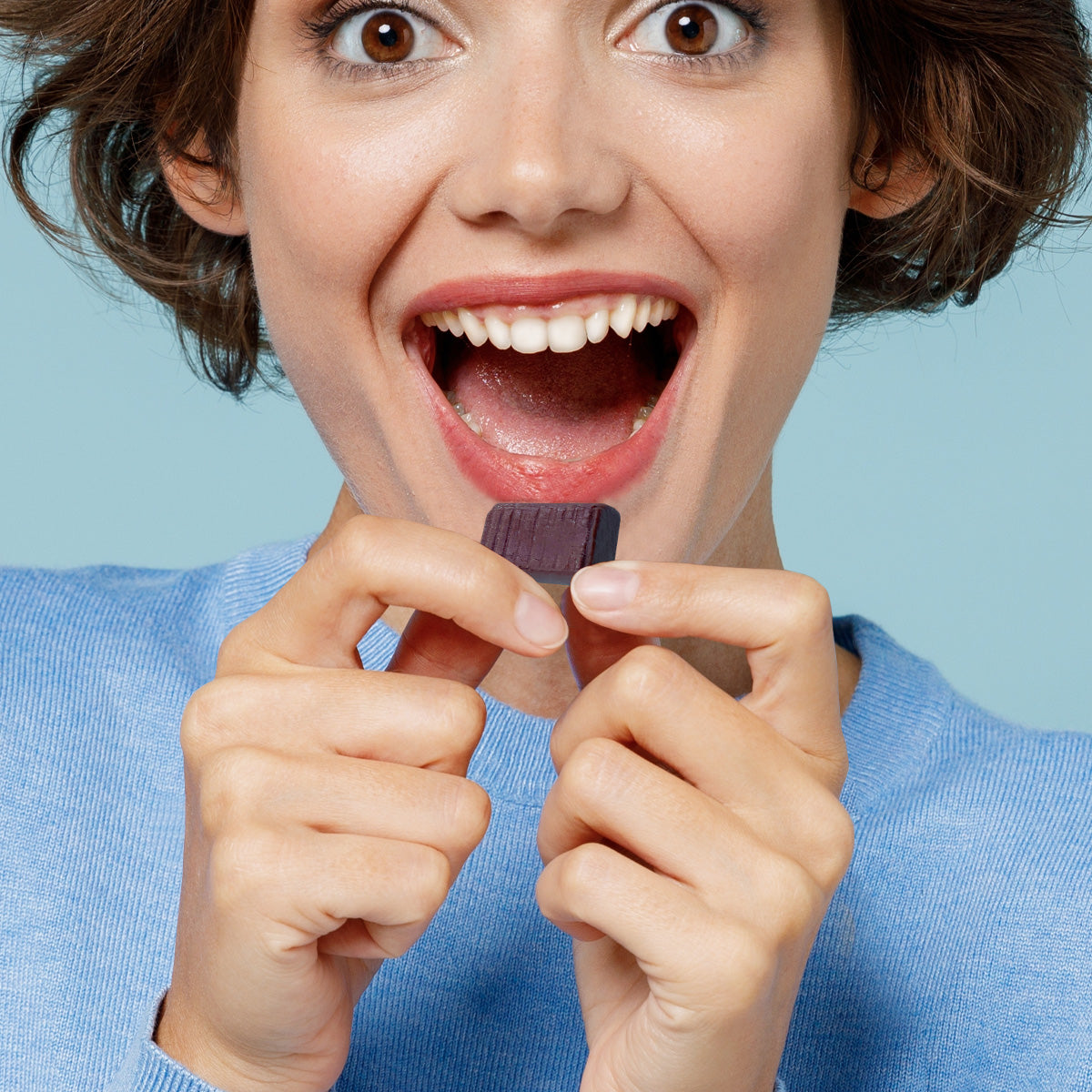 Left, excited woman holding delicious Viactiv milk chocolate calcium soft chew.
