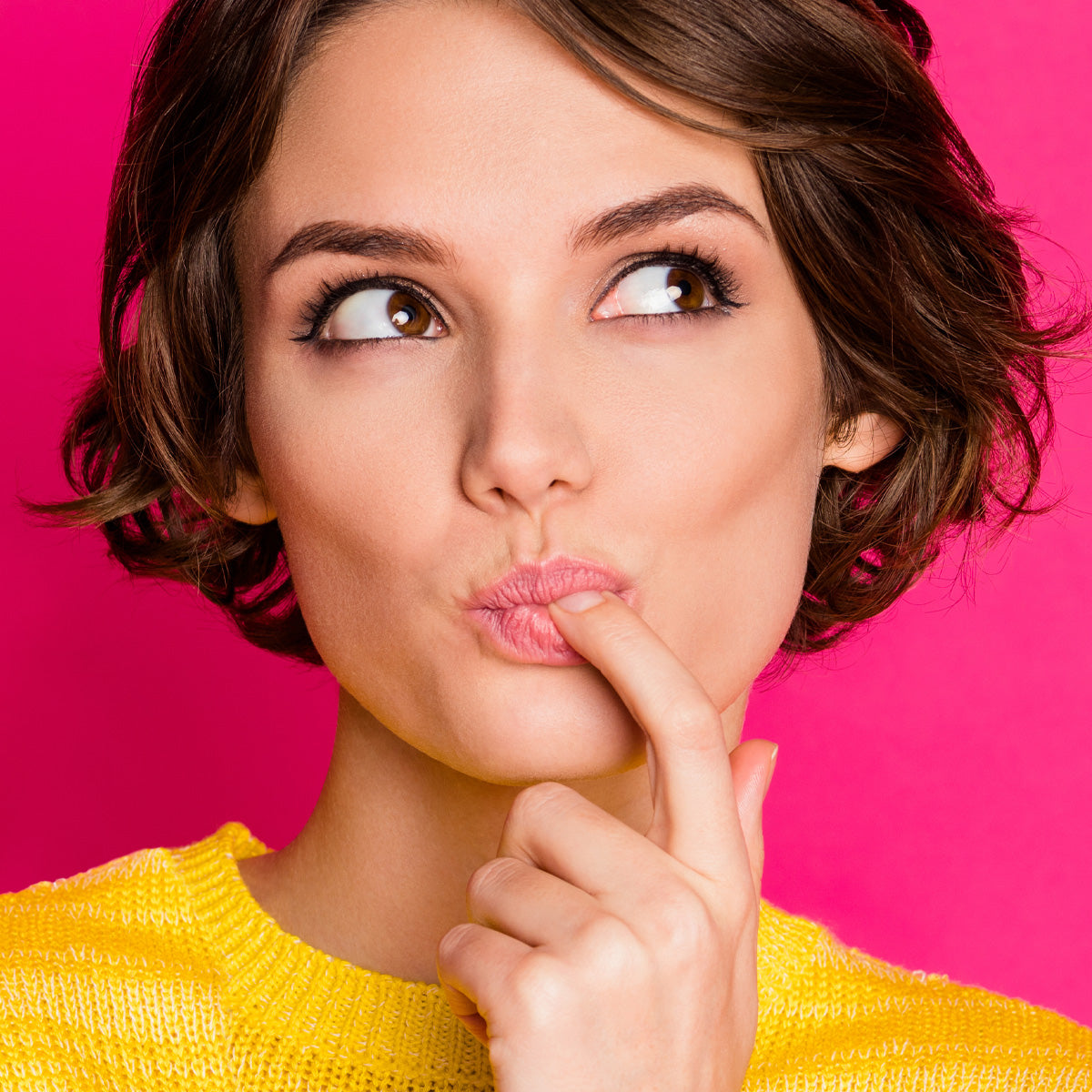 Left, Woman with her finger to her mouth after tasting something delicious.